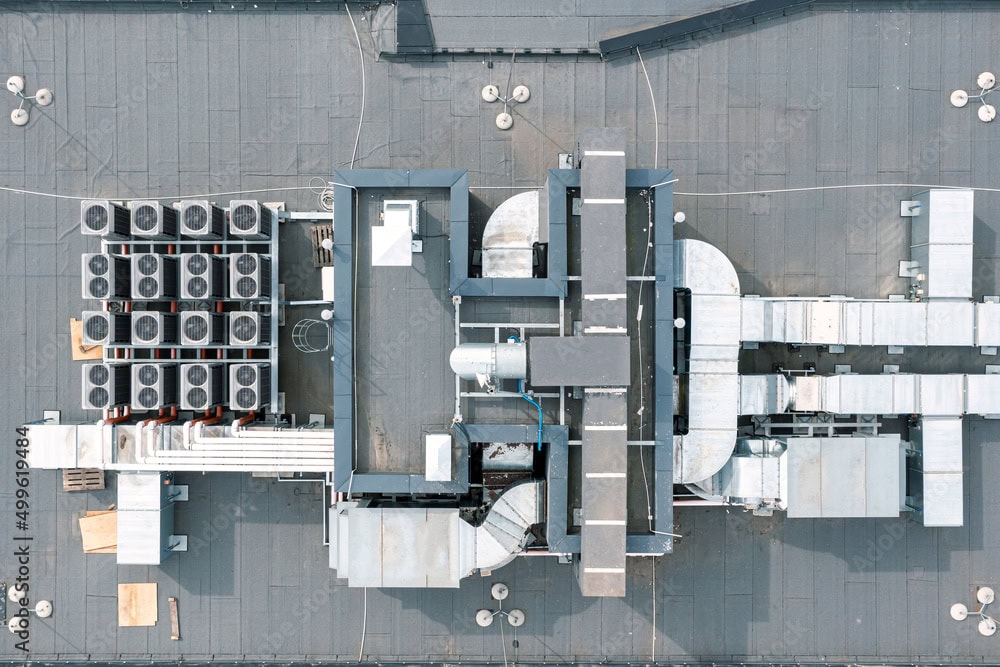 A photo showing a commercial rooftop with HVAC units and ductwork vulnerable to wildfire ember accumulation.