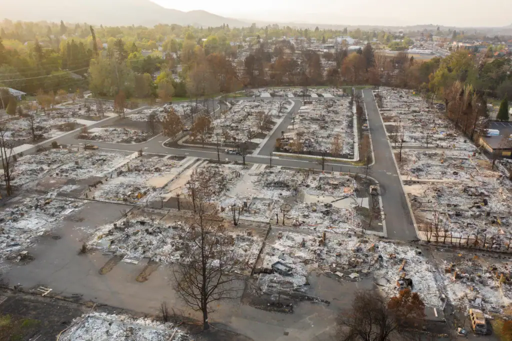 An aerial view of an entire residential neighborhood destroyed and reduced to ash, highlighting the extensive devastation and long process of recovery after Oregon wildfires.