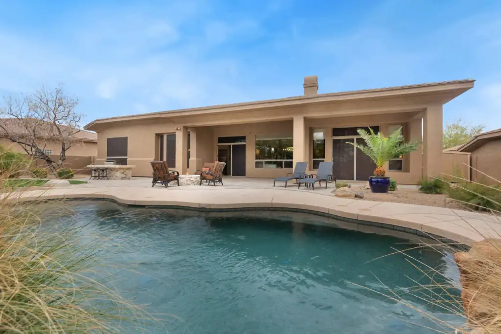 A suburban home patio with a swimming pool, representing a backup water source for fire defense when municipal pressure fails.
