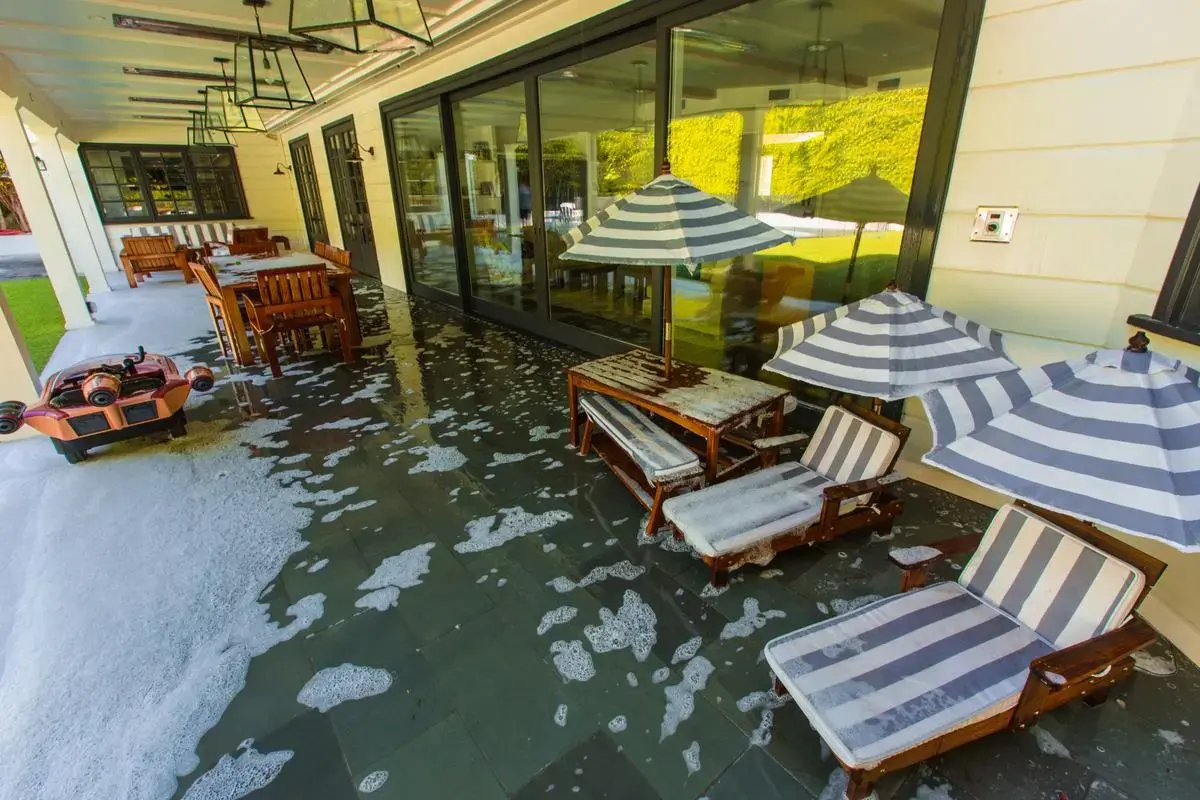 Picture of an exterior wildfire sprinkler system deploying Class A firefighting foam over patio furniture